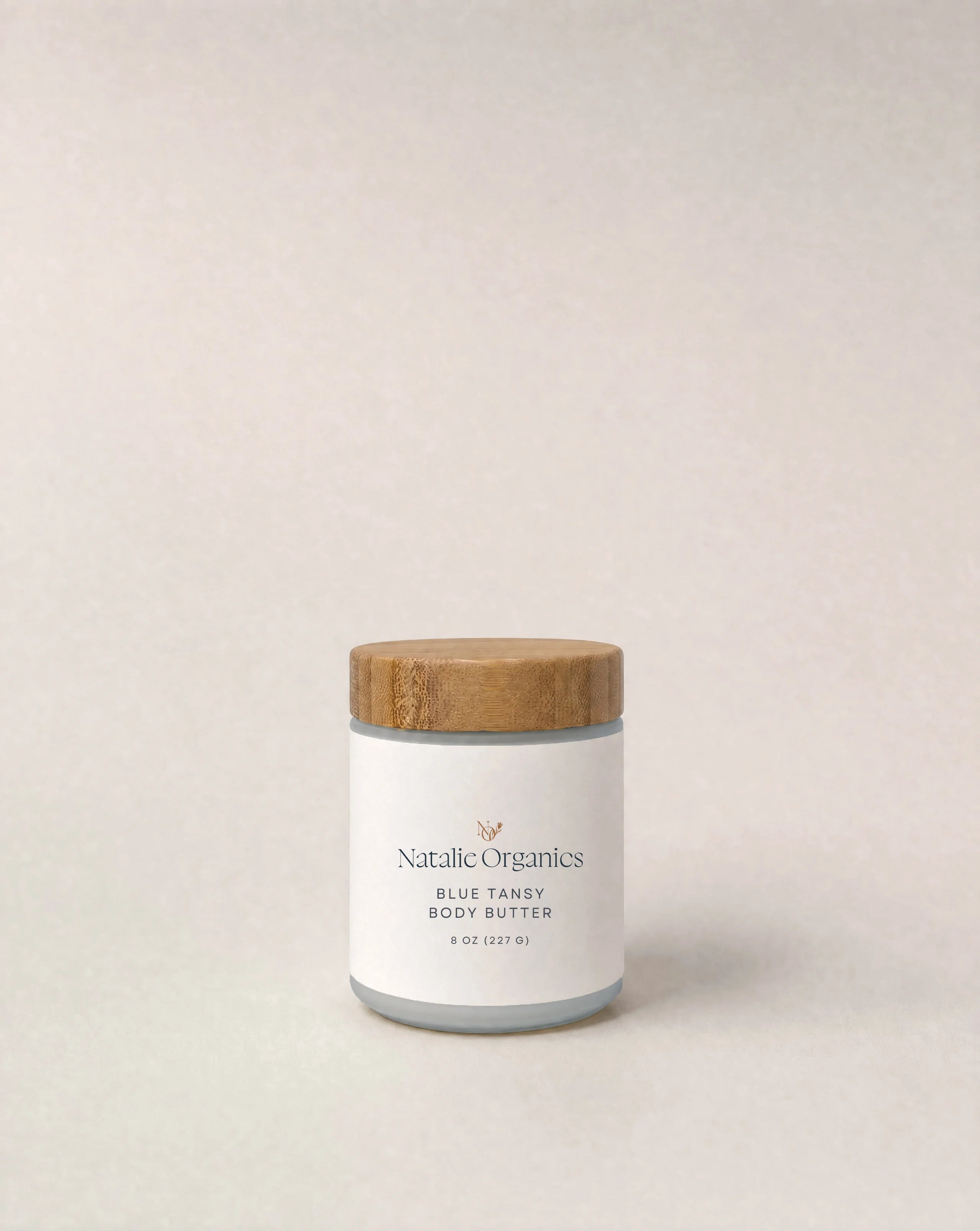 Body butter jar with cork-toned lid and white label, Natalic Organics