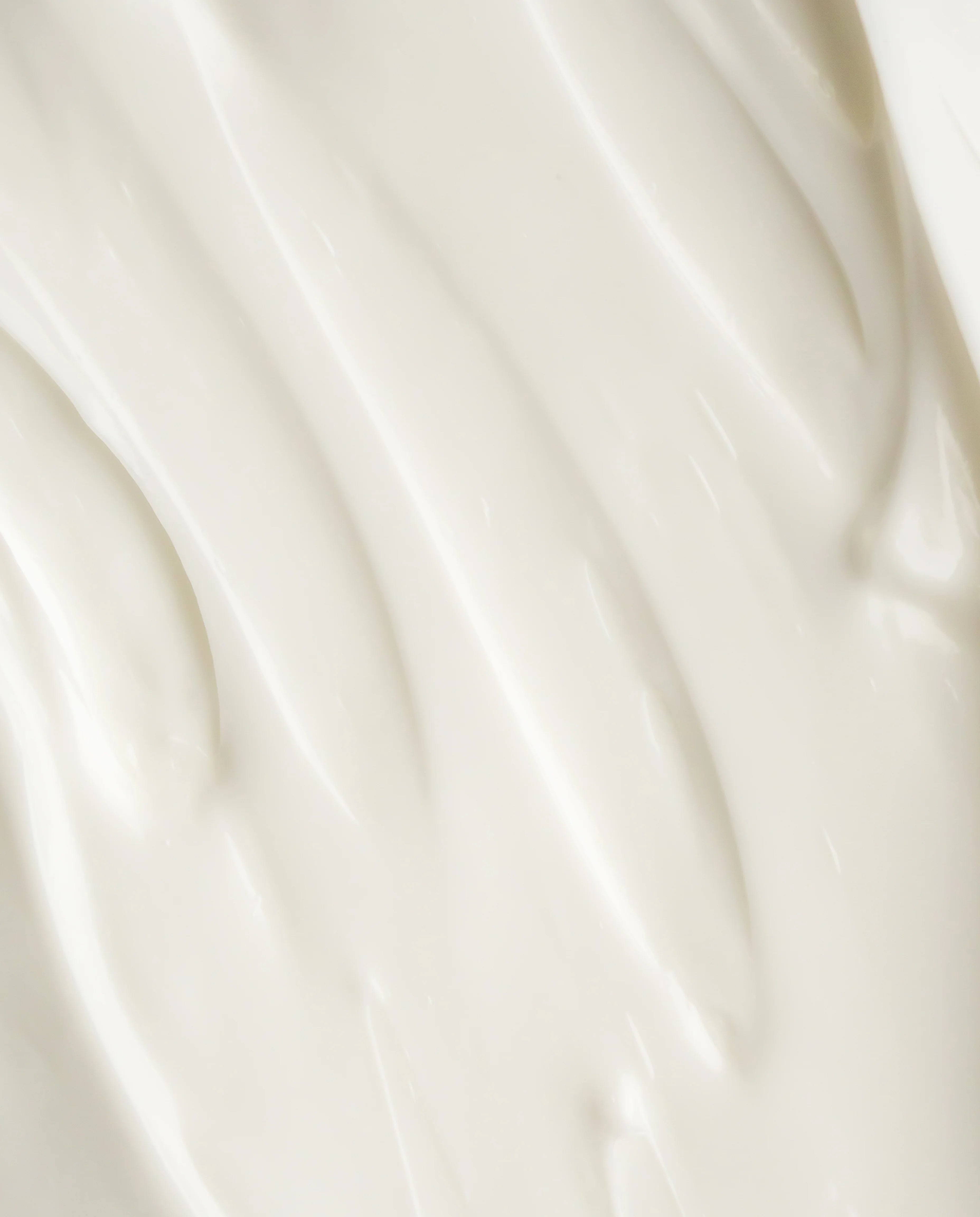 Thick white body lotion swatch with smooth glossy texture in close-up