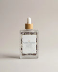 Lavender body oil in a clear glass bottle with a wooden cap and dropper