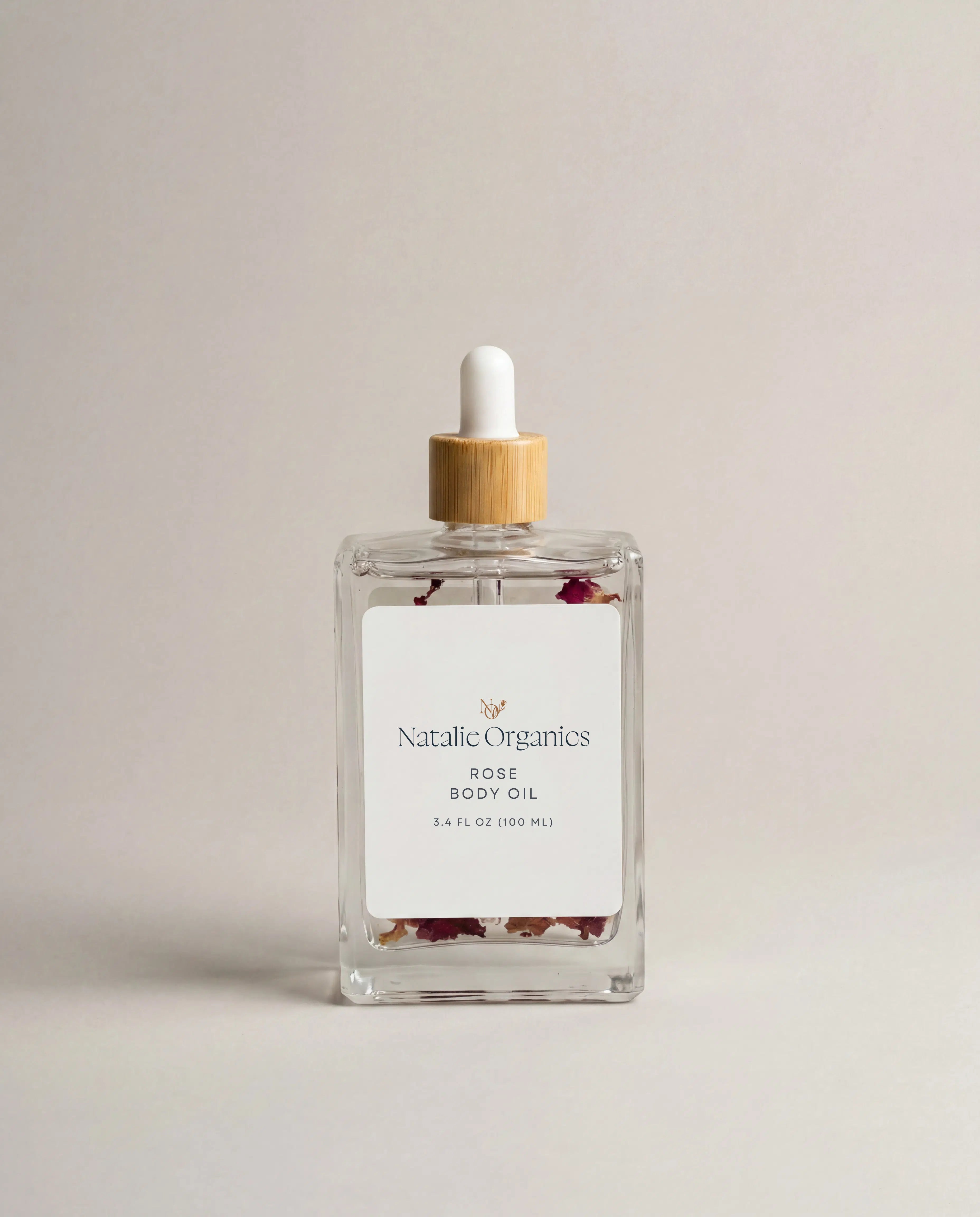Rose body oil glass bottle with white dropper and wooden cap, label reads Natalic Organics Rose