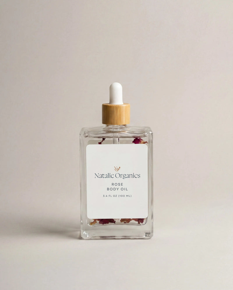 Rose body oil glass bottle with white dropper and wooden cap, label reads Natalic Organics Rose