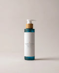 Body oil bottle with pump, white label and teal band accents