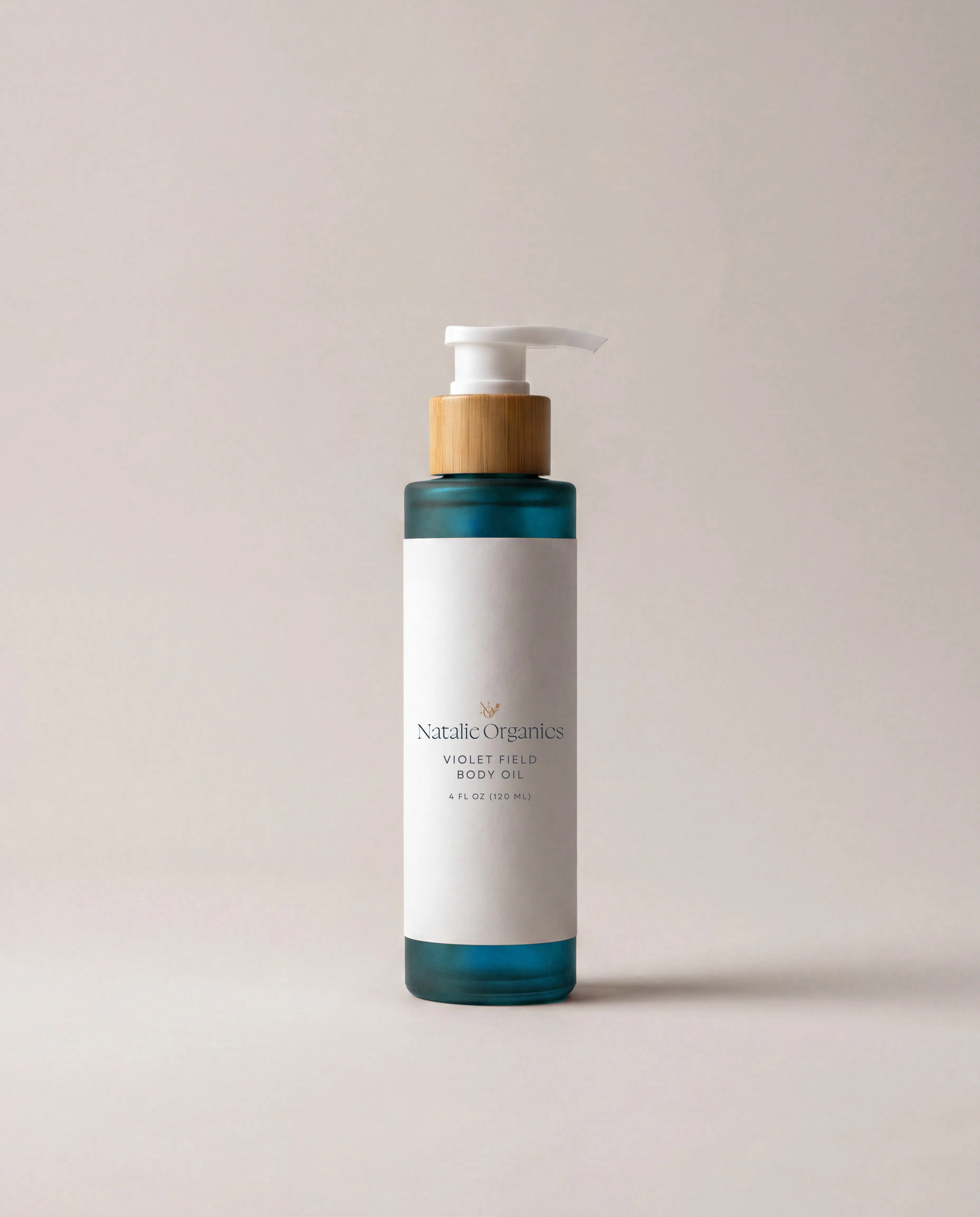 Body oil bottle with pump, white label and teal band accents