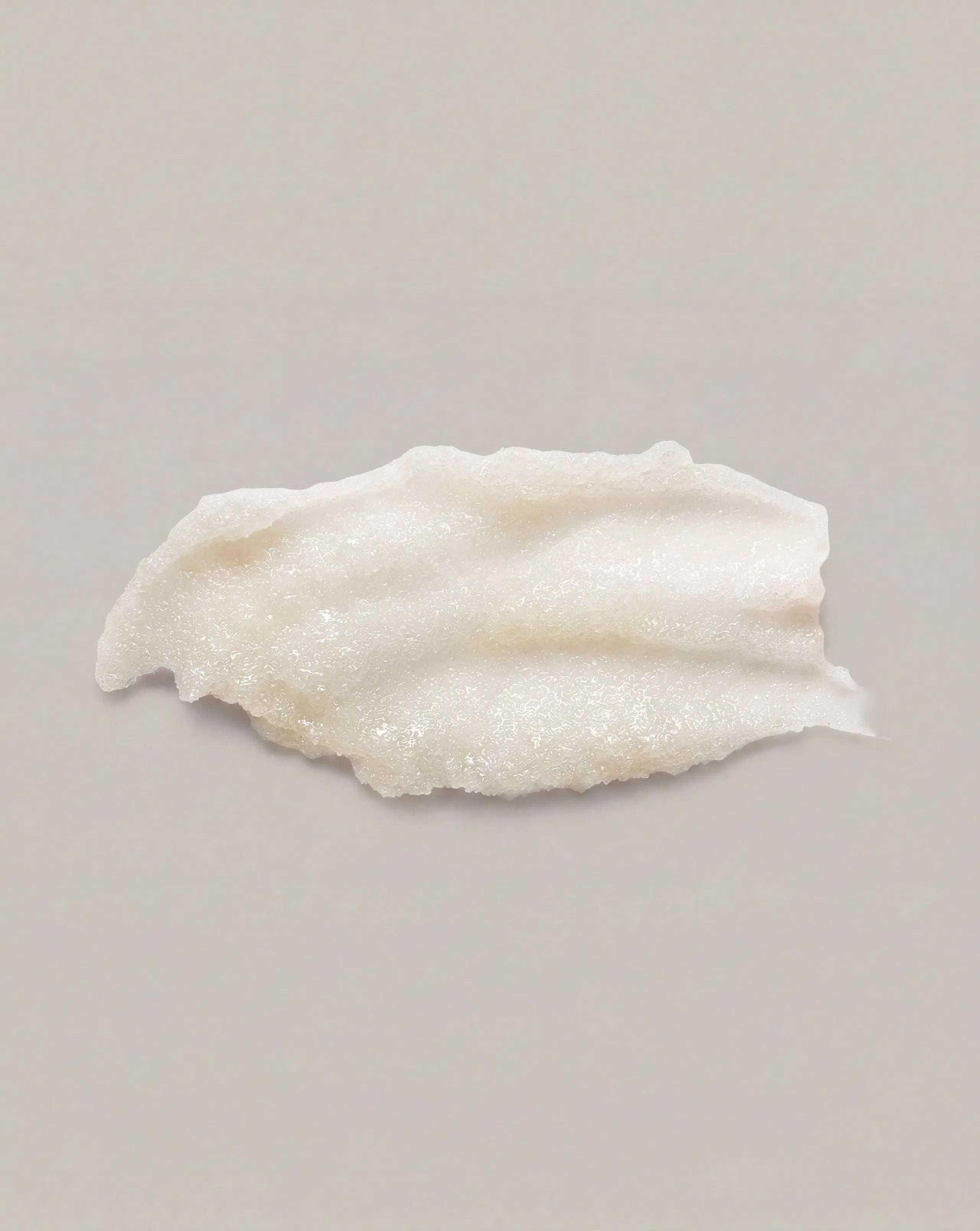 Thick white body scrub texture spread on surface