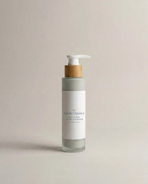 Facial cleanser pump bottle in white and gray with wood-toned dispenser