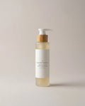Honey and oats facial cleanser bottle with pump, amber liquid, white and tan label