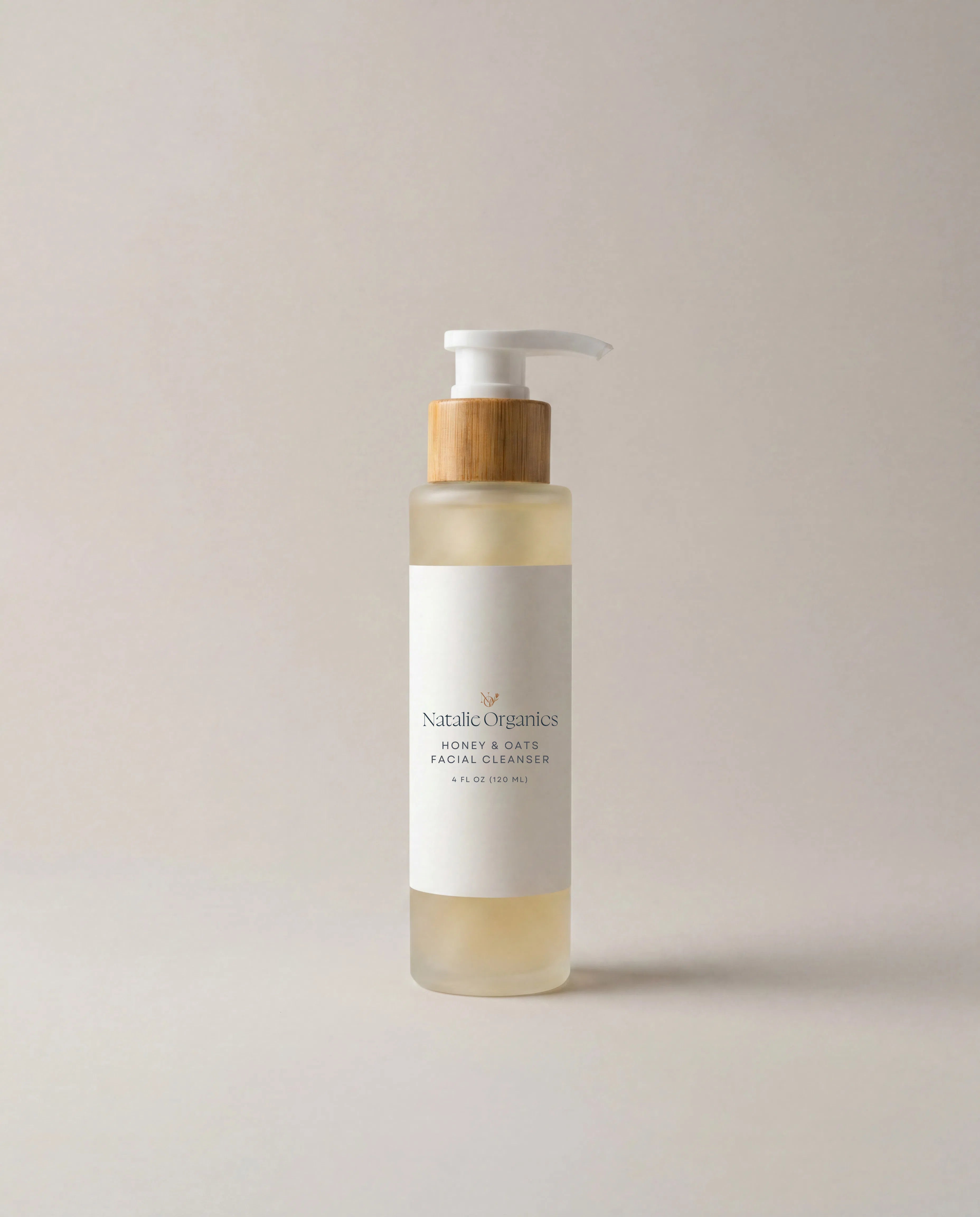 Honey and oats facial cleanser bottle with pump, amber liquid, white and tan label