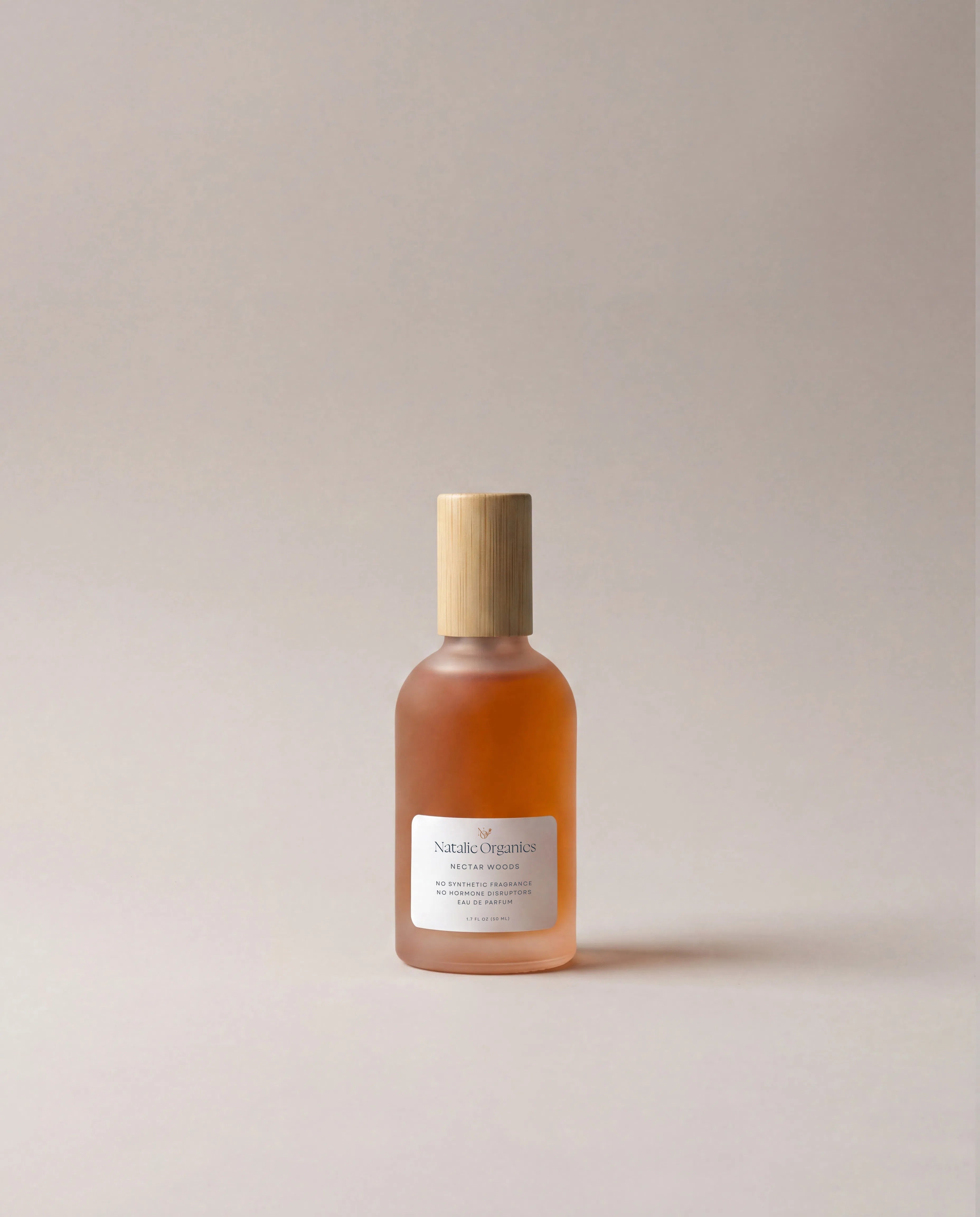 Amber glass fragrance bottle with wooden cap and white front label