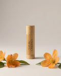 Organic lip balm in light wood cylindrical tube, vertical label