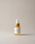 Glow serum bottle with gold collar and white pump