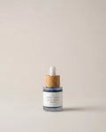Blue tansy serum bottle with white dropper, glass vial and wood collar