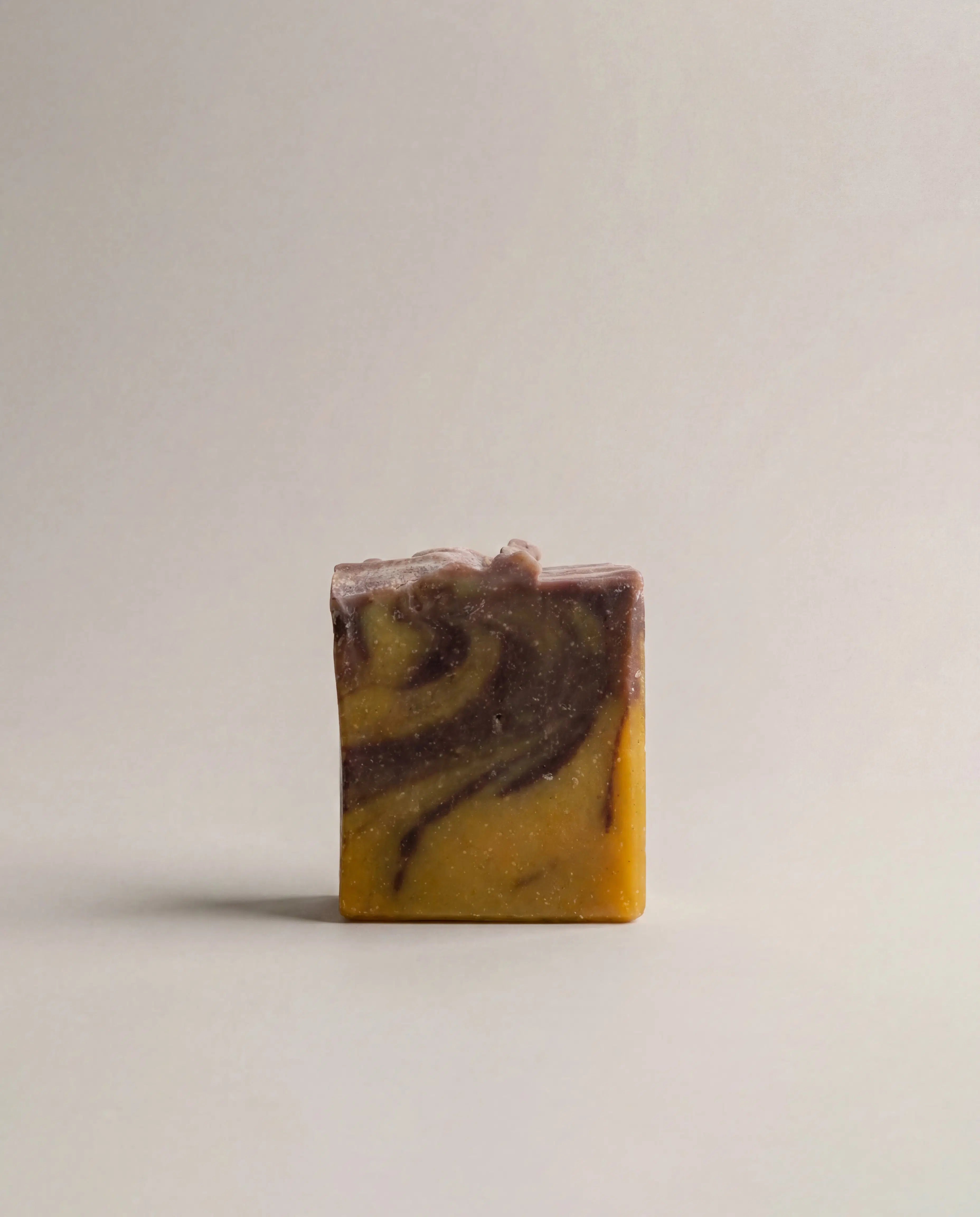 Citrus bar soap with yellow and dark brown swirl pattern