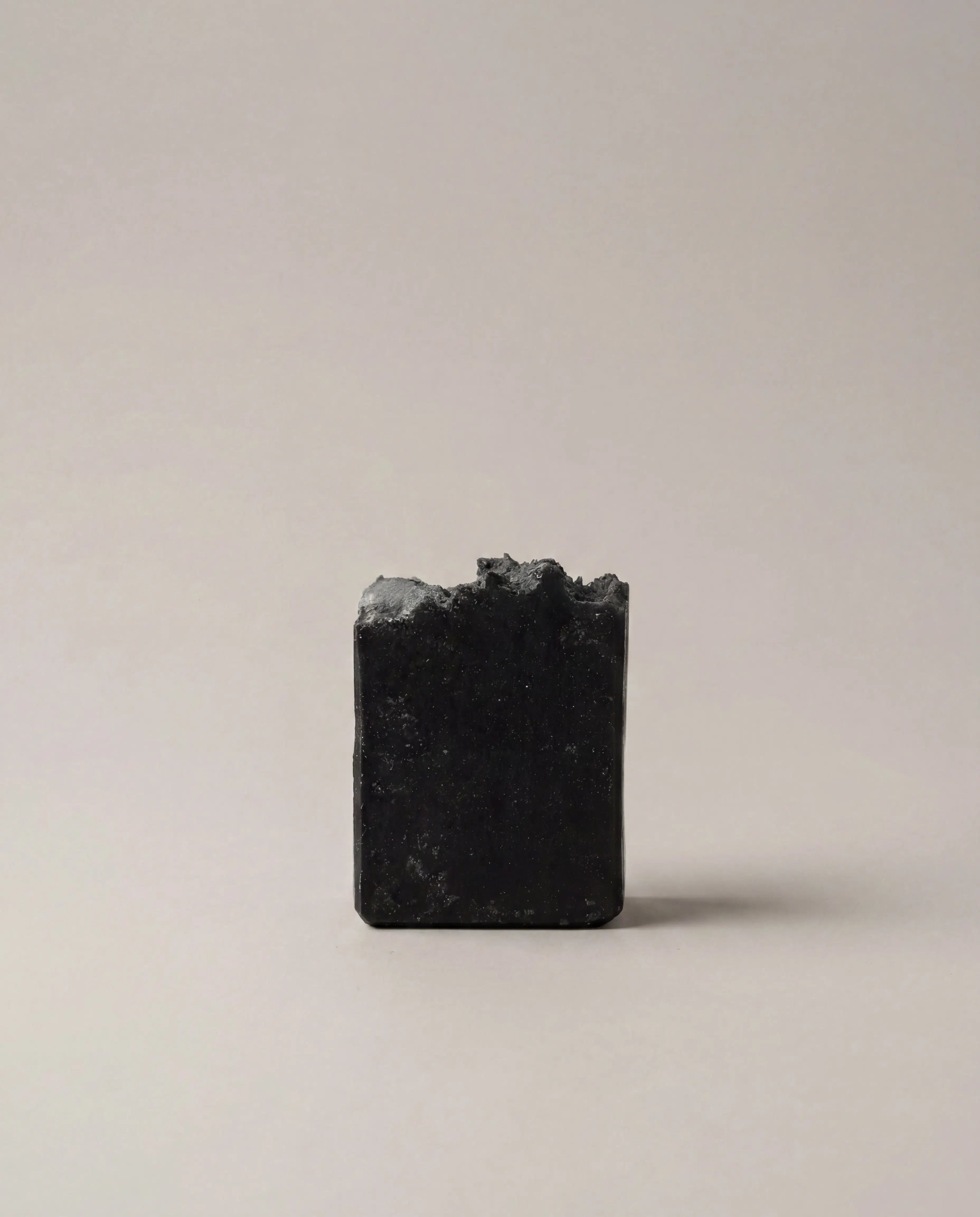 Charcoal bar soap, dark gray square block with textured surface